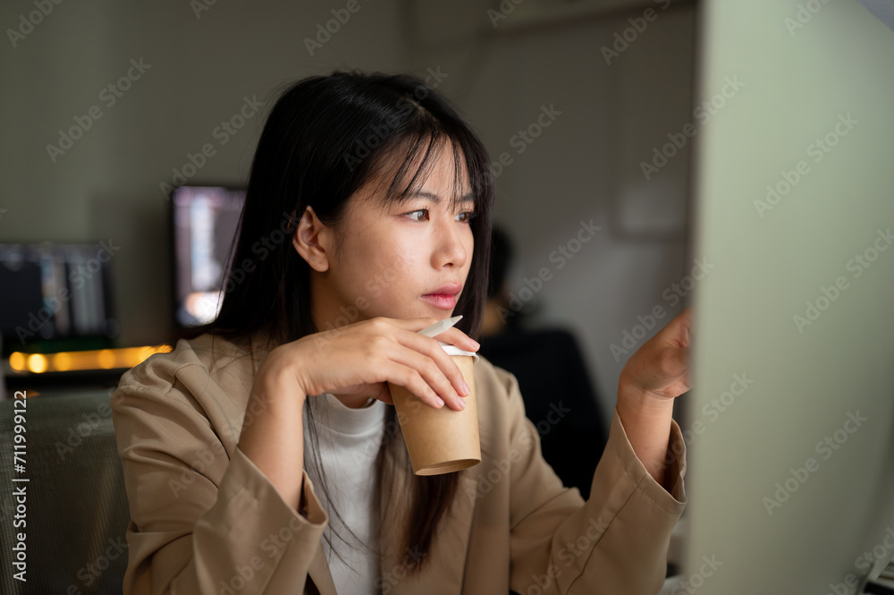 A dissatisfied businesswoman is reading emails, looking at her computer screen with a serious face. A dissatisfied businesswoman is reading emails, looking at her computer screen with a serious face.