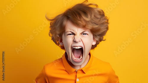 Angry irritated Caucasian boy. Full of rage. Emotional portrait of an upset preteen boy screaming in anger. © Liaisan