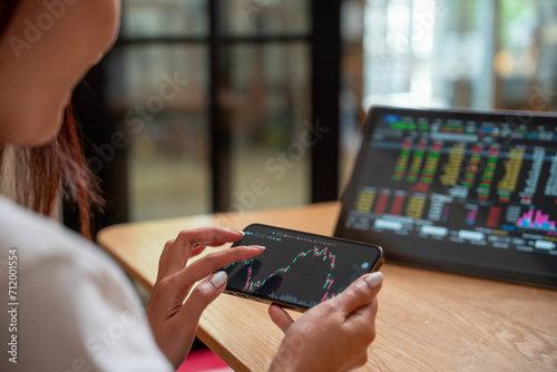 Bild auf Leinwand Successful smart woman investor and crypto trader, using laptop and smartphone,