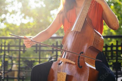 Cropped shot of an unrecognizable woman playing the cello outdoors