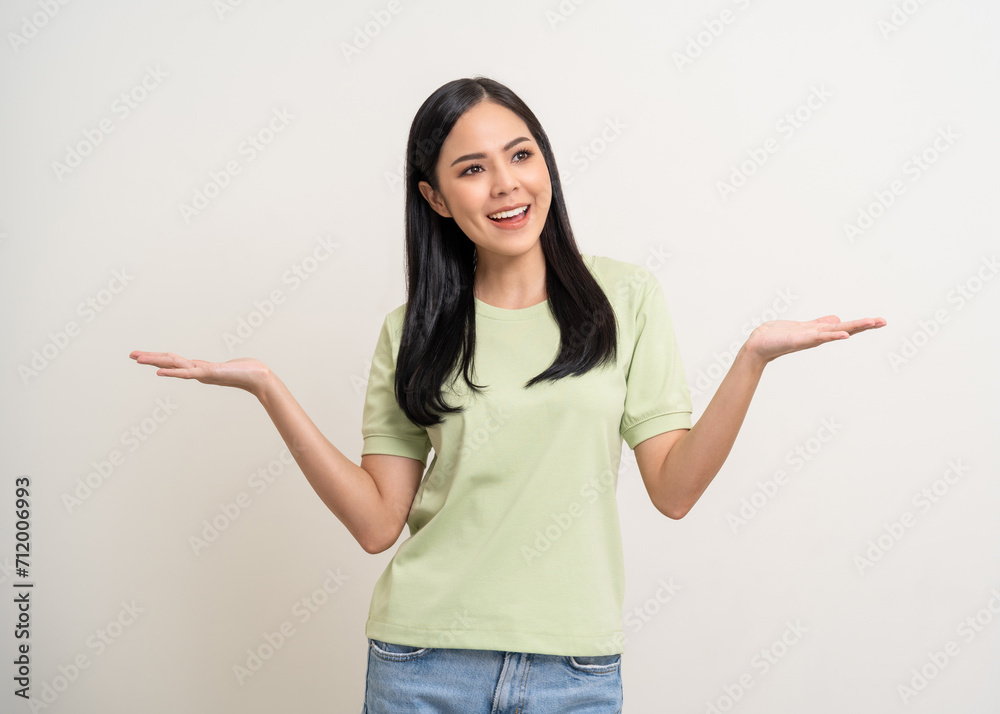 Beautiful smiling happy young asian woman in green shirt. Charming female lady open hands palm up holding something on isolated white background. Asian woman cute Pretty people looking blank space. Beautiful smiling happy young asian woman in green shirt. Charming female lady open hands palm up holding something on isolated white background. Asian woman cute Pretty people looking blank space.