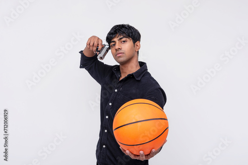 A cocky and brash young gangster with a basketball in one hand and a gun in the other, coercing someone to play. white backdrop.