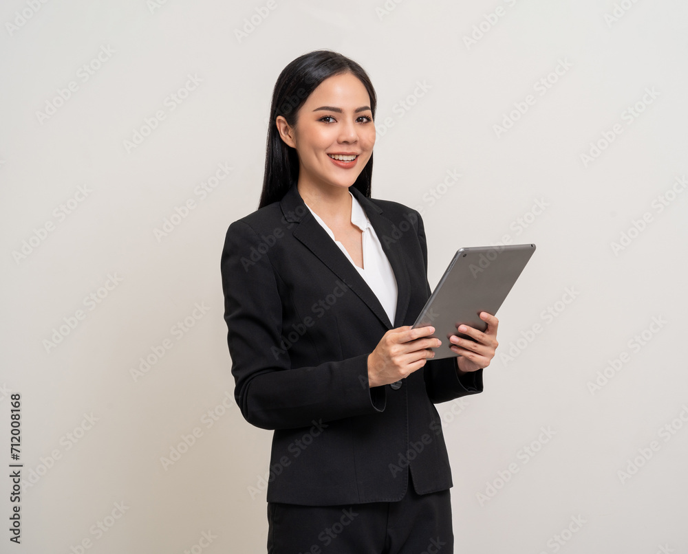 Attractive elegant young asian business woman using digital tablet standing on isolated background. Happy young latin female formal black suit holding tablet gadget working service with customer Attractive elegant young asian business woman using digital tablet standing on isolated background. Happy young latin female formal black suit holding tablet gadget working service with customer