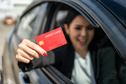 Young beautiful asian business women getting new car. Hand holding credit card payment. Car owner paying fuel pump with credit card customer mileage point loyalty reward. Driving vehicle on the road photo