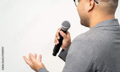 Close up businessman speaker hand holding High quality dynamic microphone and singing song or speaking talking with people on isolated white background. Male testing microphone voice for interview photo