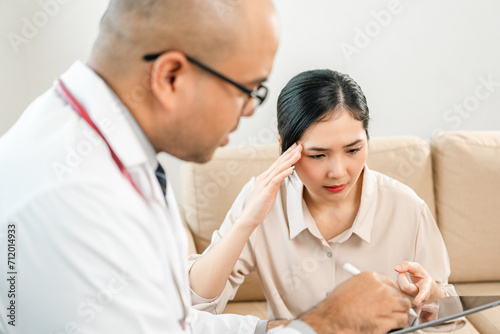 Asian Doctor and patient discussing consulting with digital tablet. Patient meet talking with Doctor giving pills bottle to woman at hospital. Medicine and health care treatment result in clinic