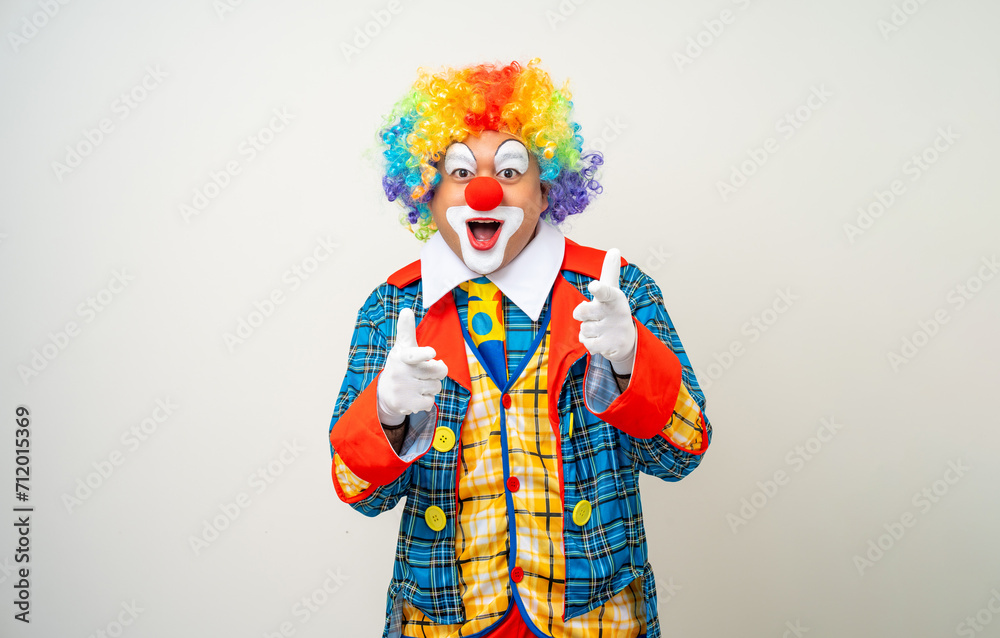 Mr Clown. Portrait of Funny comedian face Clown man in colorful uniform wearing wig standing pointing finger to camera. Happy expression amazed face male bozo in various pose on isolated background. Mr Clown. Portrait of Funny comedian face Clown man in colorful uniform wearing wig standing pointing finger to camera. Happy expression amazed face male bozo in various pose on isolated background.