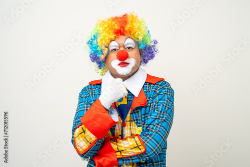 Mr Clown. Portrait of Funny face Clown man in colorful uniform standing and thinking. Happy expression male bozo in various pose on isolated background. © Chanakon