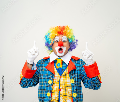 Mr Clown. Portrait of Funny face Clown man in colorful uniform standing and thinking. Happy expression male bozo in various pose on isolated background. © Chanakon