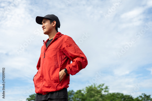 Young handsome asian man wearing sportswear standing post on running track at sport stadium outdoor. Portraits of Indian man jogging on the road. Training athlete outdoor concept. © Chanakon