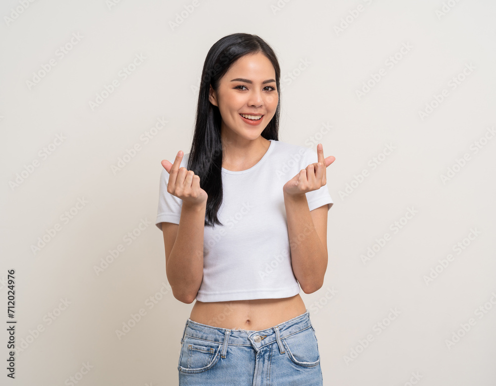 Pretty Young beautiful Asian woman standing and smiling showing mini heart sign on isolated white background. Attractive Lovely Latin female wearing white shirt feeling surprised and happy. Pretty Young beautiful Asian woman standing and smiling showing mini heart sign on isolated white background. Attractive Lovely Latin female wearing white shirt feeling surprised and happy.