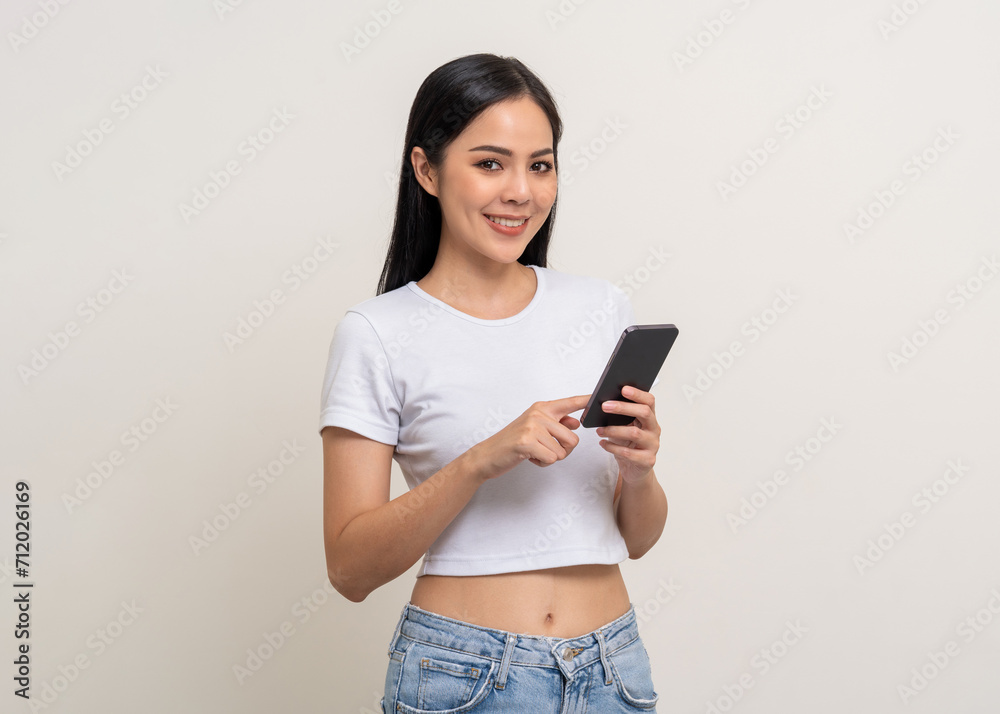 Attractive Pretty young asian woman using cellphone standing on isolated white background. Happy Excited Beautiful young asian shopping online payment with mobile phone. Playing game on smartphone Attractive Pretty young asian woman using cellphone standing on isolated white background. Happy Excited Beautiful young asian shopping online payment with mobile phone. Playing game on smartphone