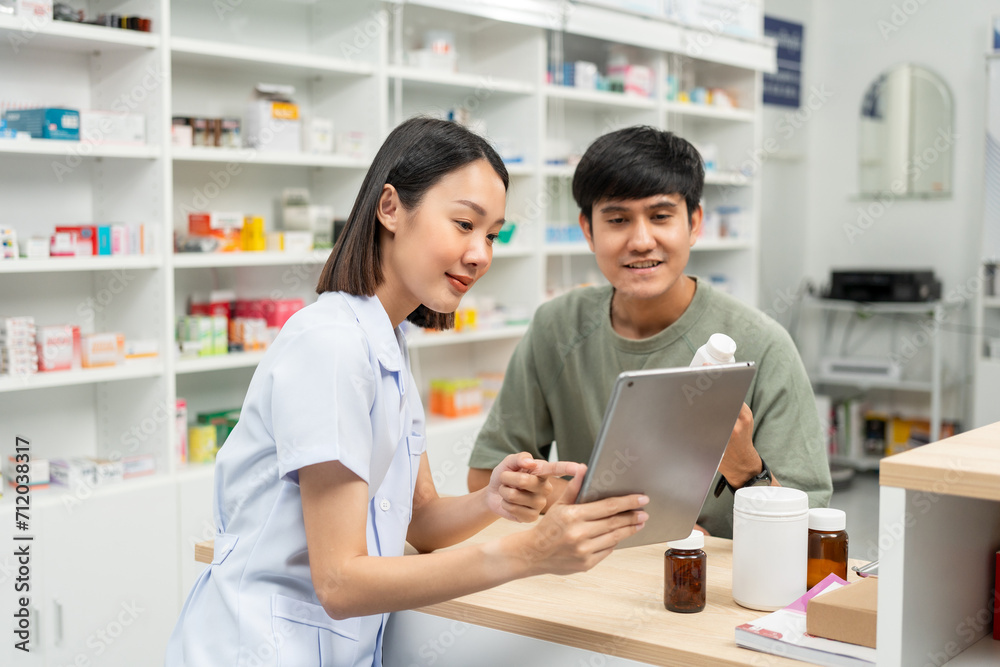 Pharmacist recommends medicines to customers.Taking the questions of medication. Asian female pharmacist giving prescription medications to customers at drugstore shelves. Pharmacist recommends medicines to customers.Taking the questions of medication. Asian female pharmacist giving prescription medications to customers at drugstore shelves.