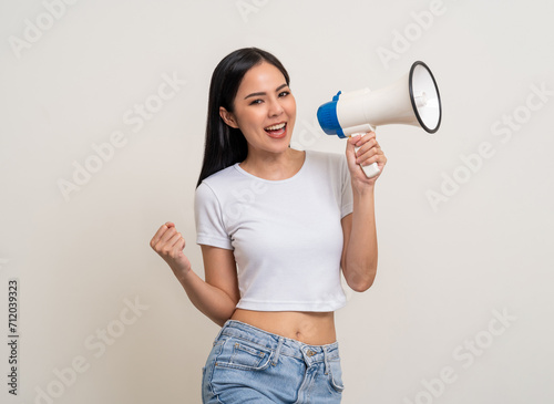 Shout out loud with megaphone. Young beautiful asian woman announces with a voice about promotions and advertisements for products at a discounted price. Standing on isolated white background.