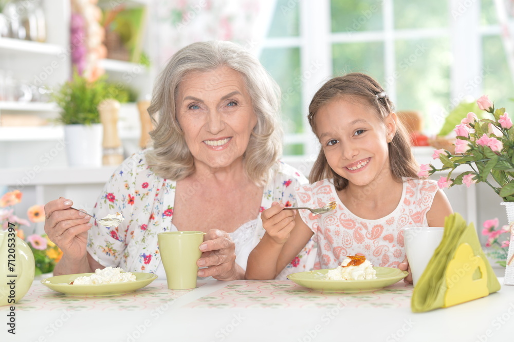 Portrait of grandmother and granddaughter having breakfast