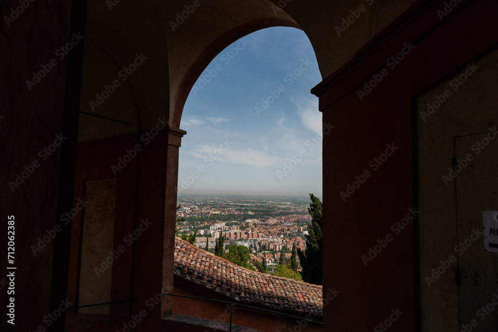 Landscape and buildings of Bologna through arch opening in famous portico