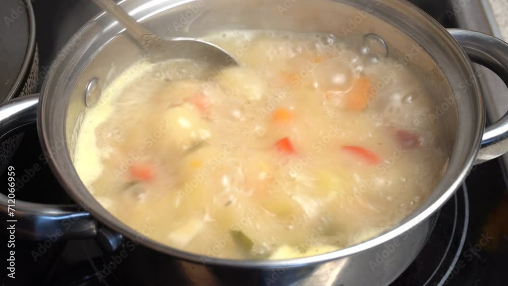 Rich pea soup with smoked ribs is cooked in a saucepan on the kitchen stove and boils. Mix of carrots, potatoes, ribs, onions and peas. Close-up. Rich pea soup with smoked ribs is cooked in a saucepan on the kitchen stove and boils. Mix of carrots, potatoes, ribs, onions and peas. Close-up.