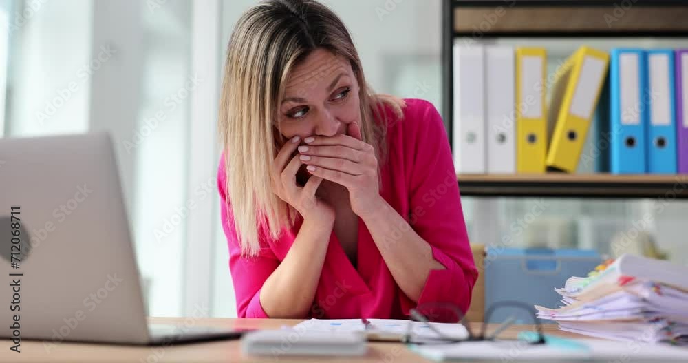 Woman worker shares gossip on mobile phone at desk in office Woman worker shares gossip on mobile phone at desk in office