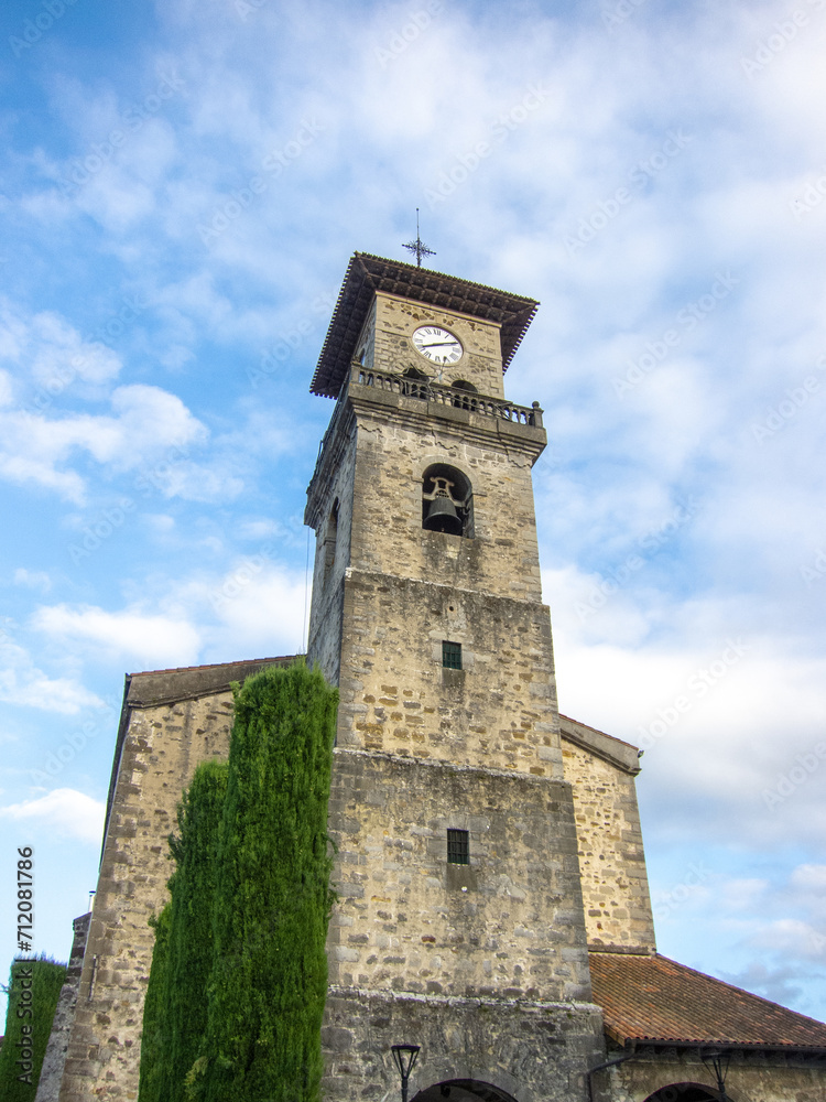 view of the stone façade of the medieval church of Santa María de Amurrio in the Basque Country with the blue sky in the background on a sunny day.