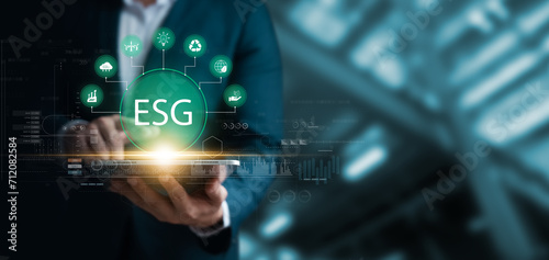 Social investment business concept. ESG and environmental governance, businessman use tablet green ESG icon, sustainable global clean energy, sustainable and ethical corporate development.