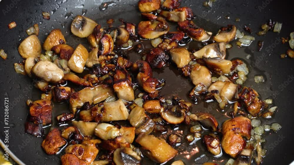 Mushrooms and onions are fried in a frying pan in sizzling oil. Close-up. Step-by-step video recipe. Cooking master class. Mushrooms and onions are fried in a frying pan in sizzling oil. Close-up. Step-by-step video recipe. Cooking master class.