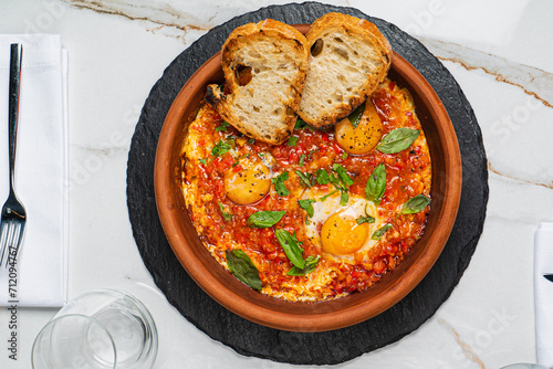 Shakshuka with eggs, tomatoes and bread