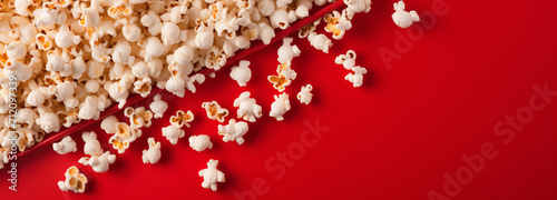 popcorn splash top view on red background space for text