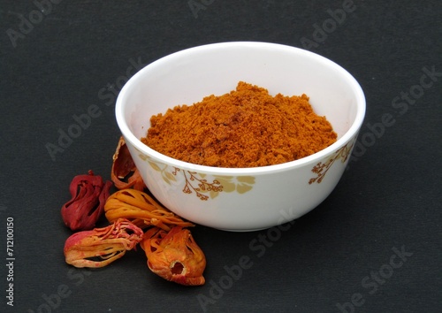 Fototapeta Naklejka Na Ścianę i Meble -  Mace spice powder in a bowl on black background side view 