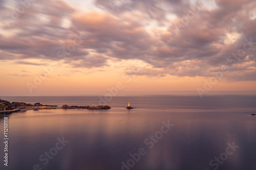 Serenity in Scarlet  Sunset Embrace with a Seaside Lighthouse