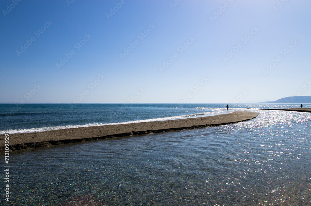The river flows into the sea on the beach, landscape