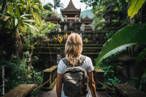 Explorer's Path. A young woman with a backpack stands at the entrance to an ancient temple in Bali, surrounded by lush tropical foliage