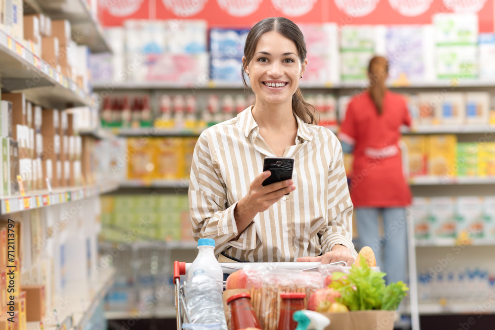 Portrait of a woman using a smartphone at the grocery store