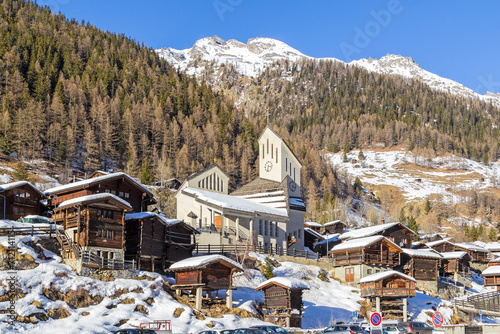 Chalet village Blattenin the Loetschental village with its modern church. The town is well known for keeping clusters of traditional wooden chalets and barns built closely together.