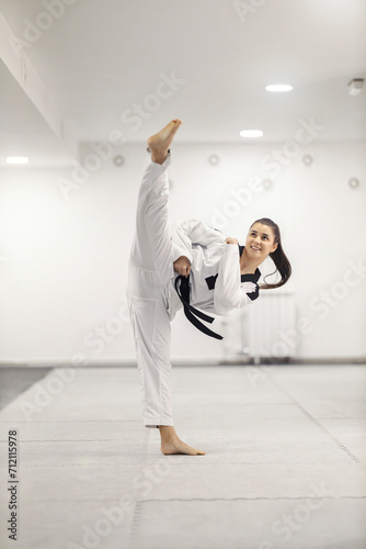 Taekwondo athlete is practicing kick at martial art school.