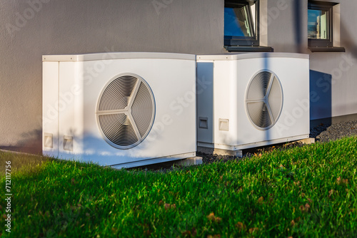 Two air source heat pumps installed outside of a modern house