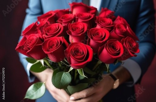 luxury bouquet of fresh red roses in the hands on light background, closeup