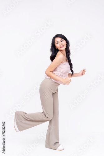 Playful young woman smiling and posing on white background
