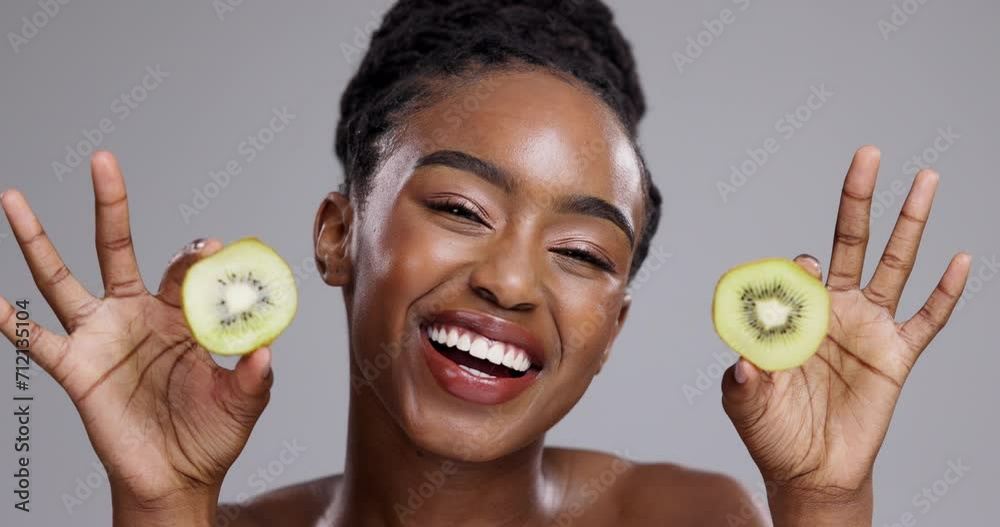Skincare, kiwi and face of happy black woman on gray background for spa wellness, beauty or cosmetics. Dermatology, studio and portrait of person with fruit for nutrition, organic or natural benefits