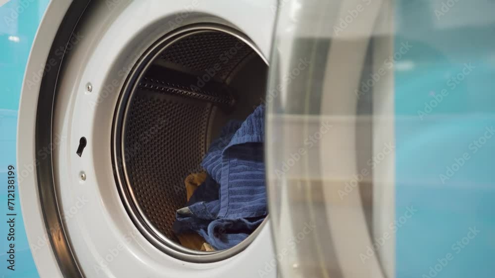 Towels getting thrown into a washing machine Towels getting thrown into a washing machine