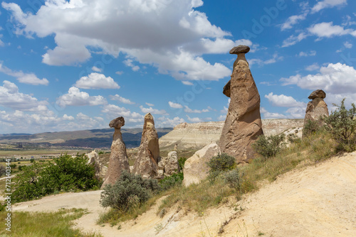 Fairy Chimneys located near Cavusin. Unique geological geological formations. Scenic clouds at background. Cappadocia, Nevsehir, Turkey (Turkiye)