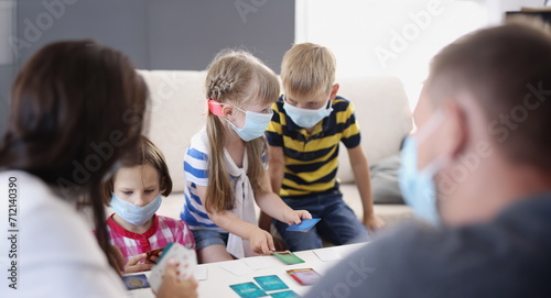 Portrait of kids in face masks  prevent virus spread in kindergarten  developing card game. Task for young generation  learn new things. Quarantine concept