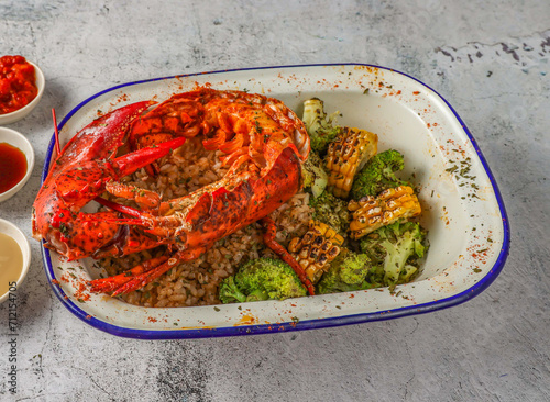half boston lobster with fried rice, grilled corn and broccoli served in isolated on grey background top view of singaporean food