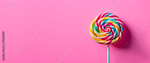a sweet and delicious lollipop isolated on pink background with copy space photo