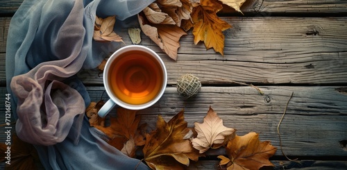 a cup of tea and a bundle of dried leaves on a wooden table