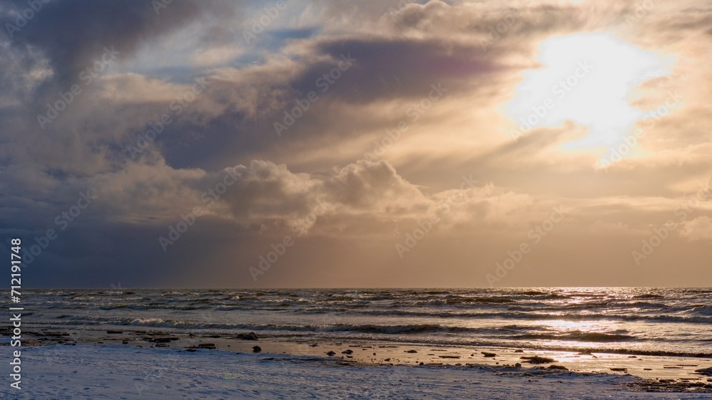 Winter Seascape. The sun rises above the horizon.