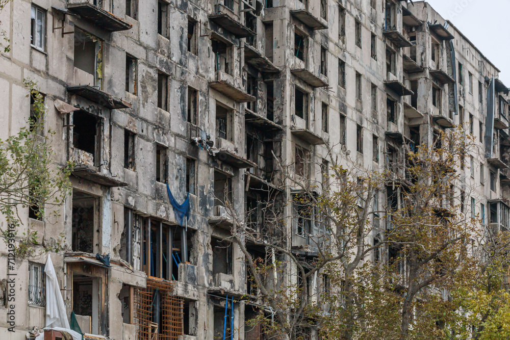 Closeup view of ruined facade of house in Mariupol.