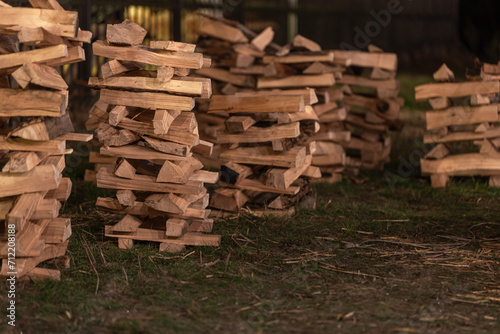 Neatly stacked firewood in the backyard in the evening.