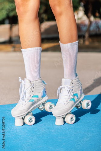 Anonymous woman in quad roller skates sneakers on colorful sports ground