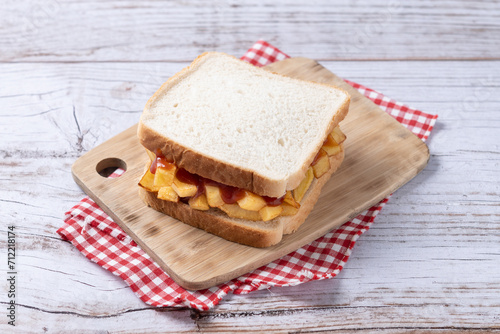 Traditional British chip butty (french fry sandwich) on wooden table