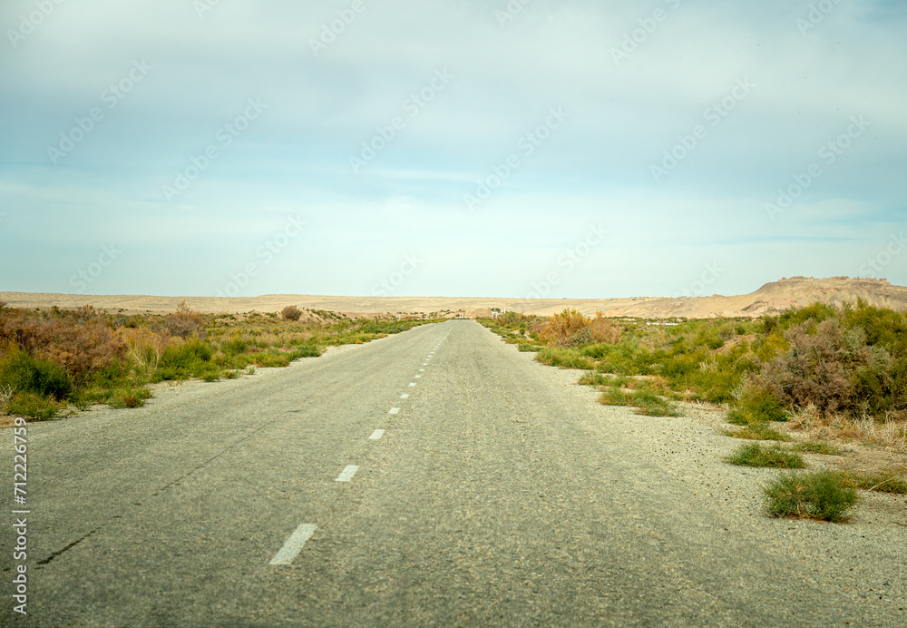 old asphalt road in the middle of the desert in the Kyzylkum desert.